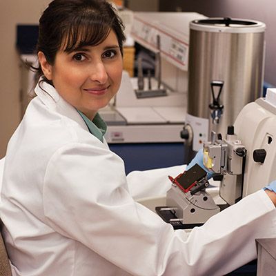 Laboratory technician sitting in front of equipment.