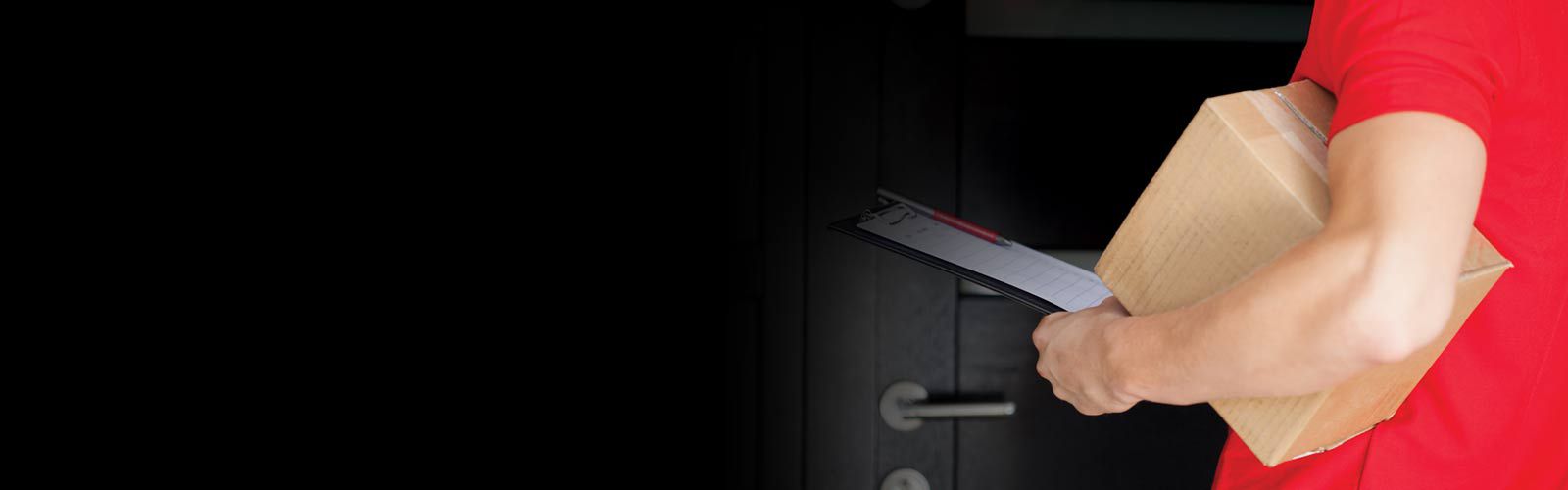 associate wearing red shirt carrying box, clipboard and pen