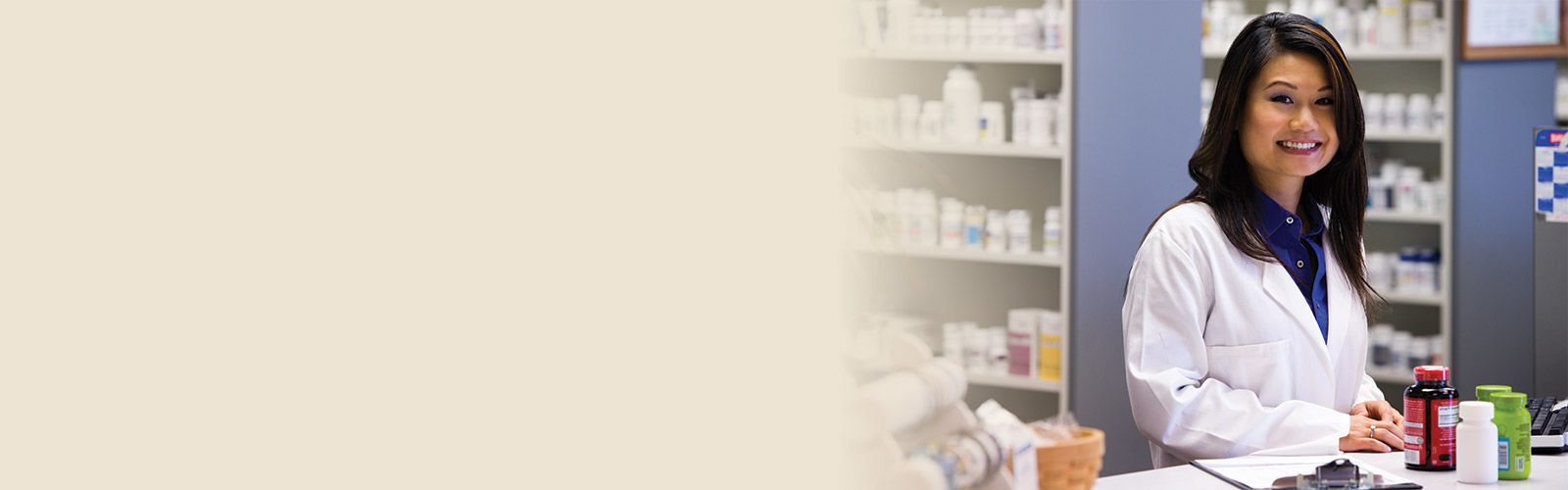 pharmacist behind pharmacy counter, smiling