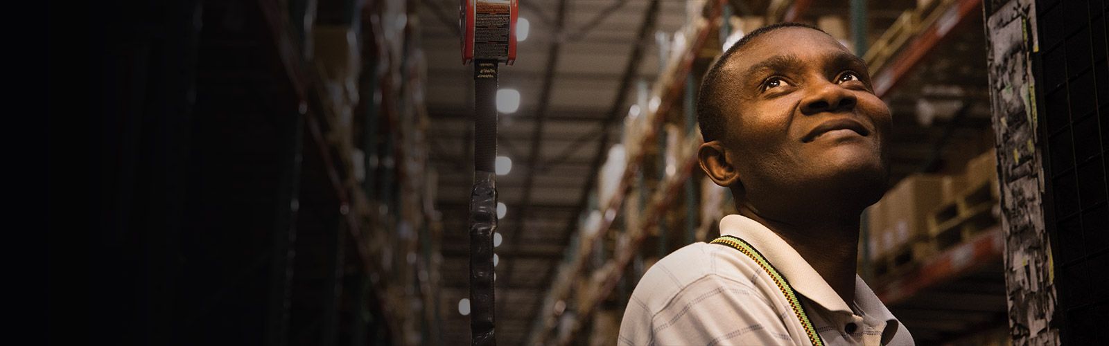 closeup of man smiling while operating fork lift in distribution center