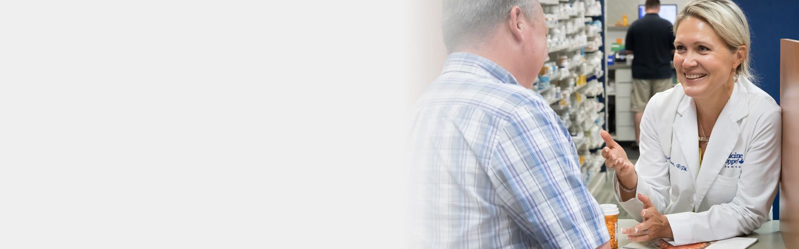 smiling pharmacist discussing prescription with customer