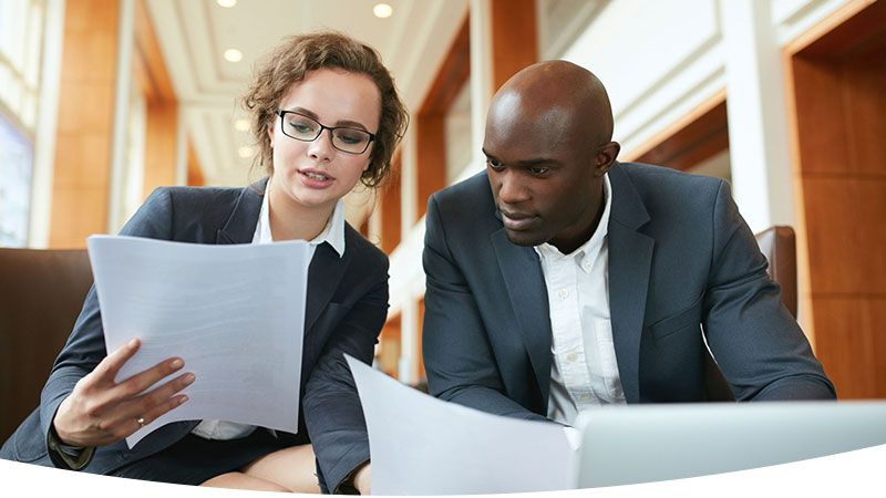 business professionals in lobby reviewing documents