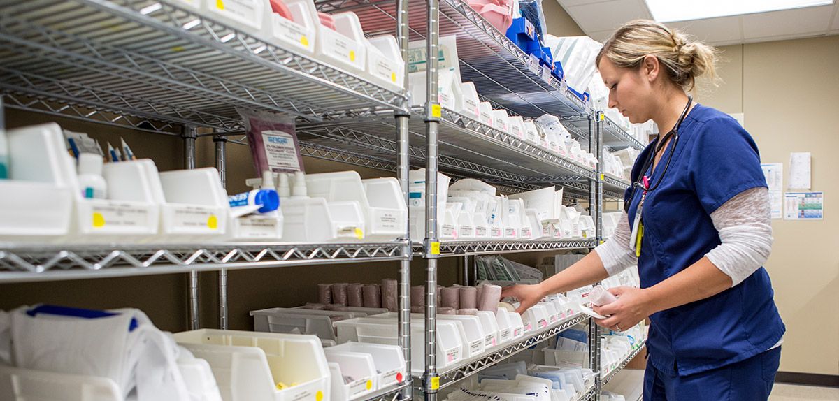 nurse in medical supply room holding gauze.