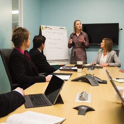 professionals in conference room listening to presenter