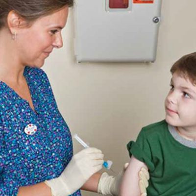 Nurse giving a boy an injection.