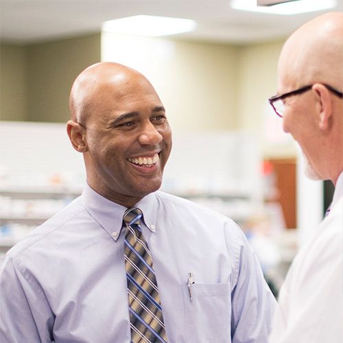 business professional and pharmacist talking and smiling