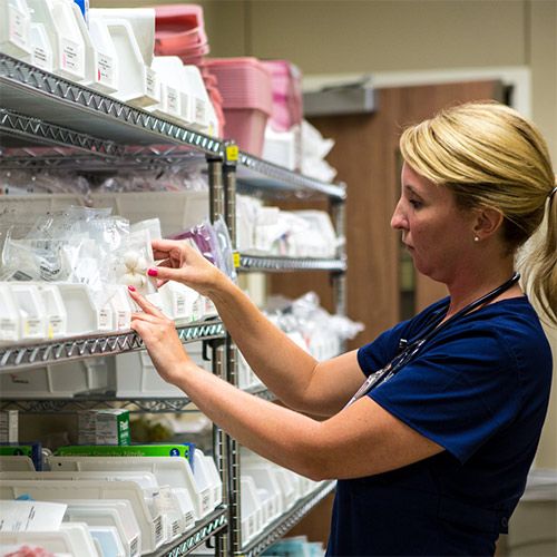 nurse selecting supply from a shelf