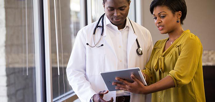 Sales rep showing a doctor something on her tablet.