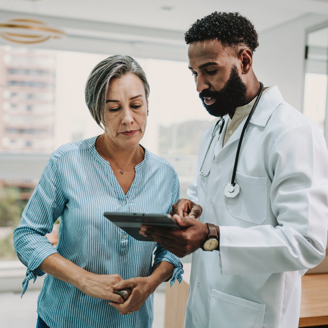 Oncologist and practice administrator using technology suite provided by oncology physician network.