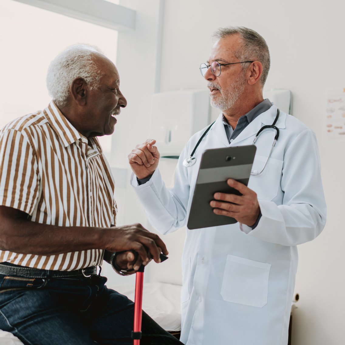 Oncologist using AI-enabled medical scribe technology during appointment with patient of an independent oncology practice.