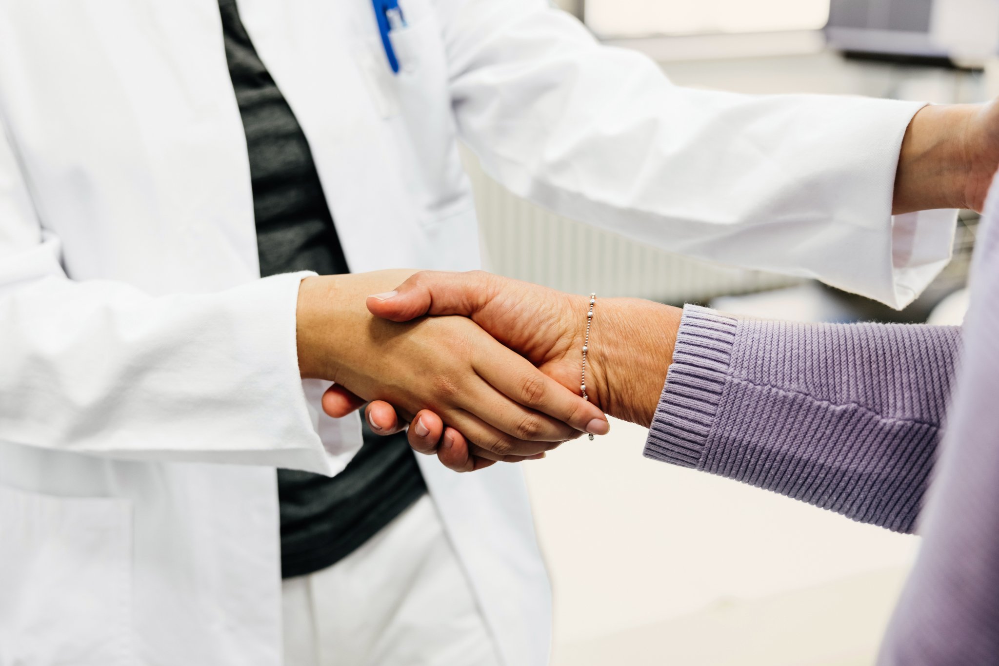 Oncology physician shaking hands with cancer patient in community oncology practice.