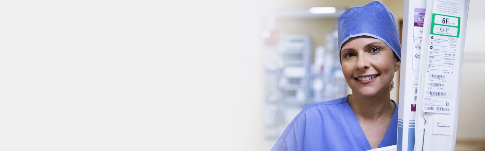 Nurse in scrubs holding product.