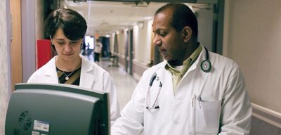 A doctor and pharmacist consult at a hospital.