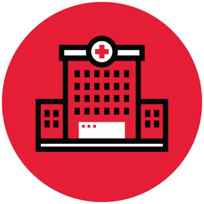 Icon illustration of a hospital in a red circle.