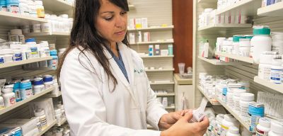 Female pharmacist holding medication.