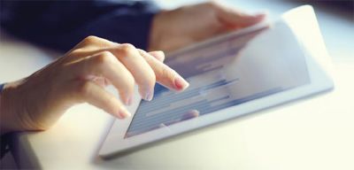 Hand scrolling through charts on a tablet.
