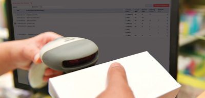 Close up of a hand-held scanner reading a barcode on a prescription.