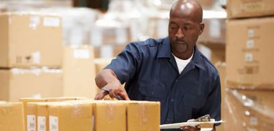 Supply chain employee in warehouse checking inventory.